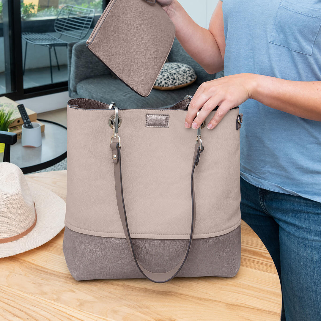 Lady placing a wristlet into a Faux leather Gisele handbag#colour_bronzebge