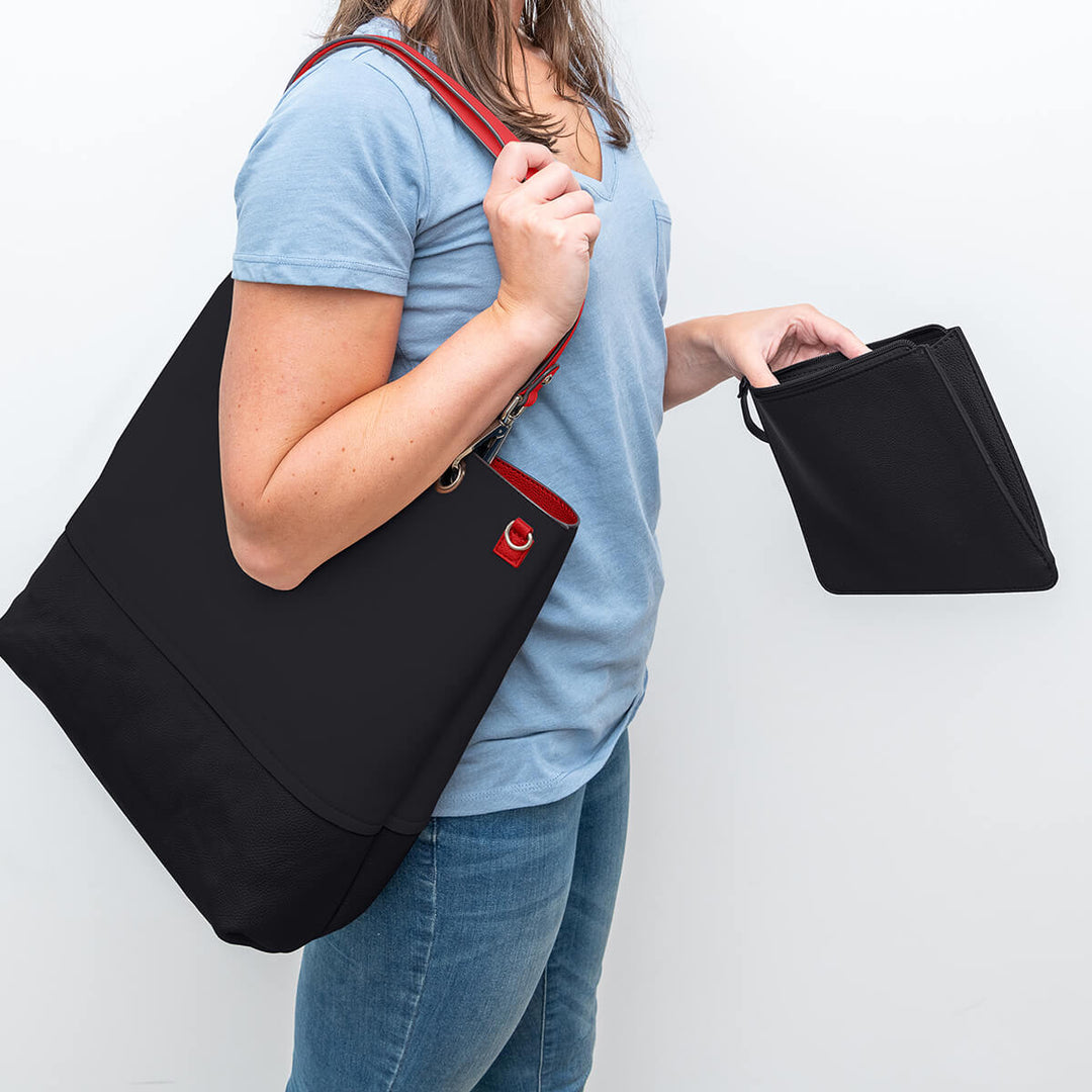 Lady carrying a black Gisele faux leather handbag with wristlet pouch#colour_scarletblk